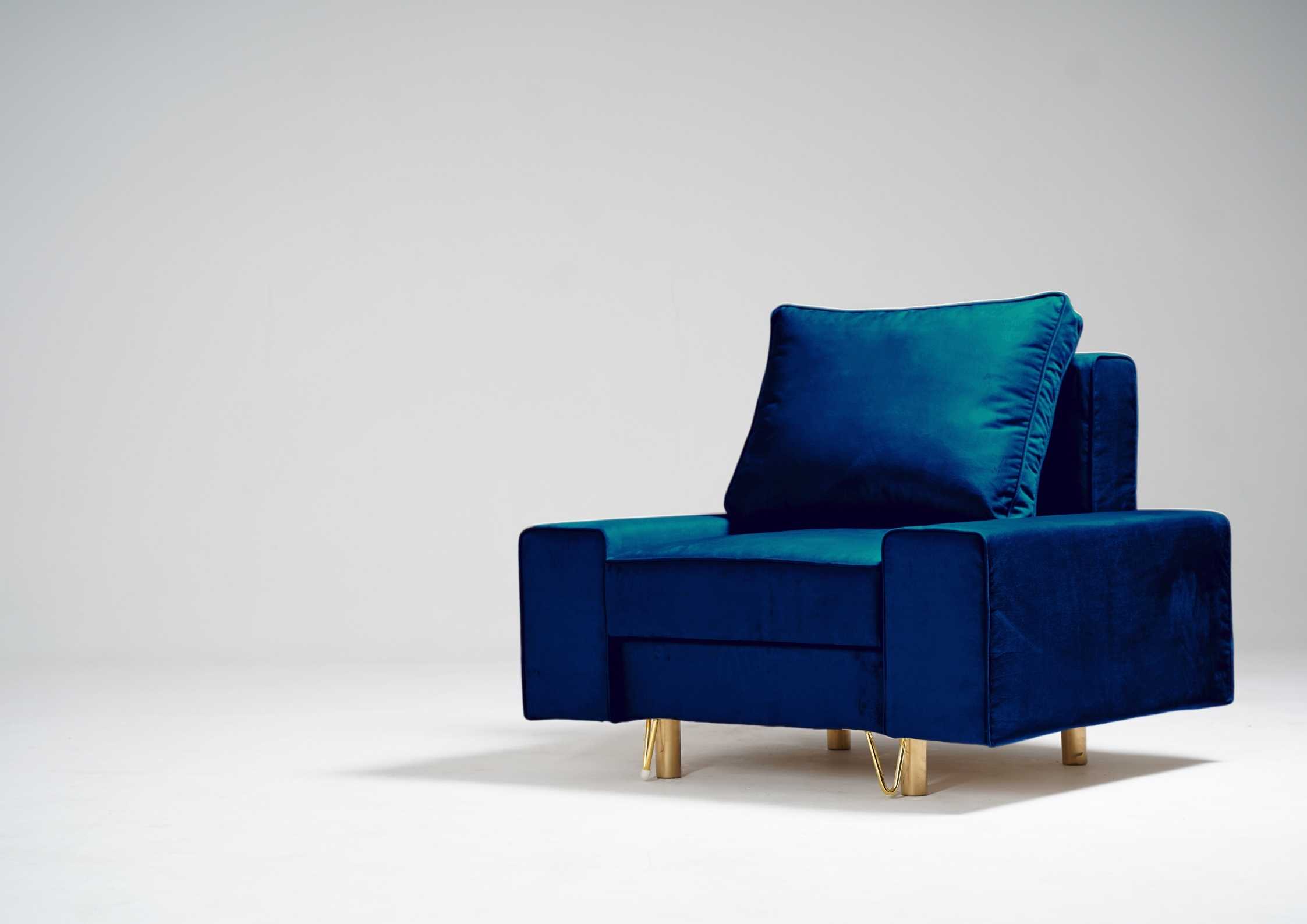 Granatowy fotel na złotych nogach